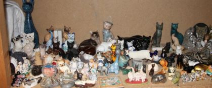 A Poole pottery seated cat together with a large quantity of model cats including Royal Crown Derby,