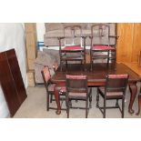 An Edwardian mahogany extending dining table on cabriole legs and pad feet on casters,