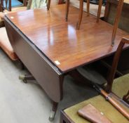 A Regency mahogany sofa table with drop flaps on a single pedestal and brass cappings