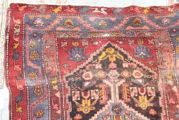 A 19th century Bakhitari rug with a red ground and central medallion