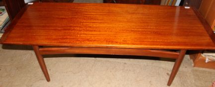 A teak coffee table on tapering legs