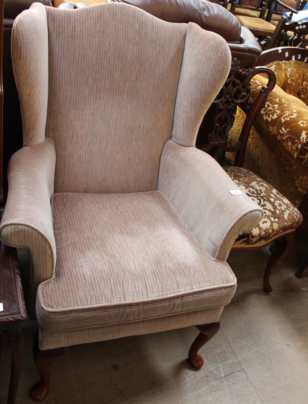 An upholstered wing back elbow chair,