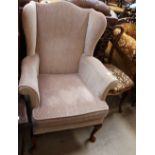 An upholstered wing back elbow chair,