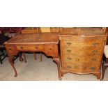 A 20th century walnut writing table with a cross banded top above three drawers on shell capped