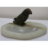 A cold painted bronze parrot perched on an onyx ashtray base