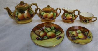 A Coalport fruit painted miniature part tea set, comprising a teapot, cream jug,