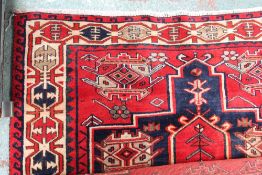 A late 19th century Persian red ground rug with geometric decoration