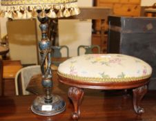 A footstool with a woolwork top on leaf carved legs and scrolling feet together with a painted