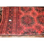 A red ground rug with geometric patterns