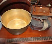 A bronze cooking pot together with a leather cartridge case and a shotgun cartridge belt