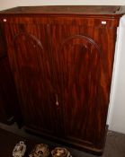 A Victorian mahogany wardrobe with a moulded cornice above a pair of cupboard doors enclosing