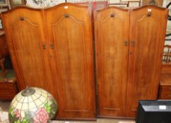 A 20th century walnut three piece bedroom suite comprising two wardrobes and a dressing table