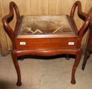 A piano stool with curbed handles above a pad upholstered seat on cabriole legs and pad feet