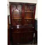 A reproduction mahogany bookcase with glazed doors to the top and cupboards and drawers to the base