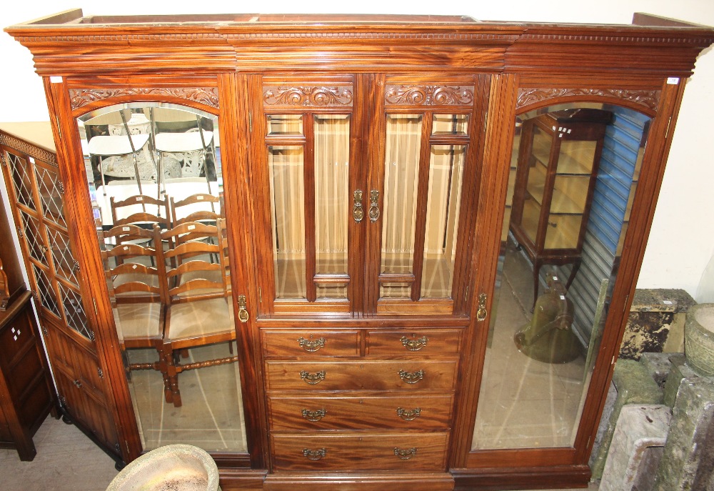 A large Edwardian walnut triple wardrobe,