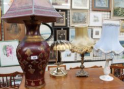 A pottery table lamp together with two other table lamps and a brass desk lamp