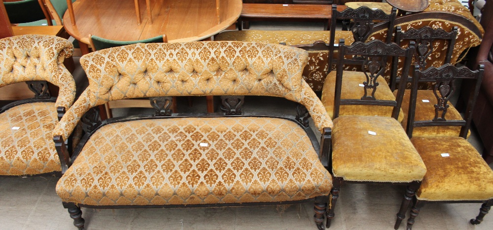 A late Victorian ebonised salon suite comprising a settee, arm chair,