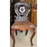 A Victorian mahogany hall chair with a shield shaped back and solid seat