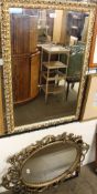 An oval gilt wall mirror together with two other wall mirrors and pictures