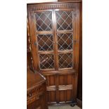 A 20th century oak standing corner cupboard and a set of four ladder back dining chairs