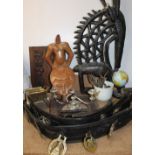 Assorted horse brasses on leather straps together with African carvings,
