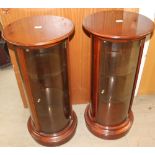 A pair of 20th century mahogany display cabinets of circular form with a moulded top and plinth