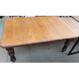 A 19th century extending oak dining table on fluted turned tapering legs includes additional