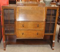 A mid 20th century oak bureau bookcase, with a central sloping fall and drawers,