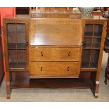 A mid 20th century oak bureau bookcase, with a central sloping fall and drawers,