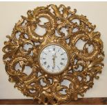 A gilt wall clock decorated with scrolling leaves,