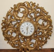 A gilt wall clock decorated with scrolling leaves,