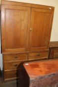 A pine linen press with cupboard doors,