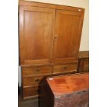 A pine linen press with cupboard doors,