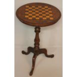 A VICTORIAN WALNUT GAMES TABLE, the circular top with a satinwood and rosewood checker board,