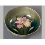 A WILLIAM MOORCROFT BOWL, decorated with pink and yellow lilies on a mottled green ground, impressed