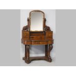 A VICTORIAN MAHOGANY DRESSING TABLE, the arched mirror supported on floral carved pillars with short