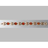 A 9CT YELLOW GOLD AND CARNELIAN BRACELET, cabochon carnelians interspaced with cut-out disks, ending