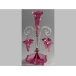 A CRANBERRY GLASS EPERGNE, the central fluted vase flanked by twist rope spirals, each spiral with a