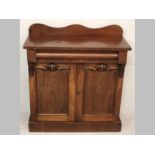 A VICTORIAN MAHOGANY CHIFFONIER, the cross-banded top with a wavy rail, housing a long cushion