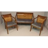 A FRENCH OAK SUITE, comprising a settee and a pair of armchairs, the backs with carved scrolling