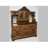 A LATE 19TH CENTURY GERMAN OAK SERVER, the arched top with a heavily carved frieze above two lead-