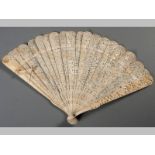 A CHINESE IVORY BRISÉ FAN, comprising nineteen sticks and two guards all engraved with scenes of