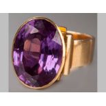 AN 18CT YELLOW GOLD AND AMETHYST RING, oval amethyst on a raised rectangular base, ending on a solid