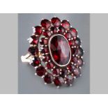 A 9CT YELLOW GOLD BOHEMIAN GARNET RING, centre oval garnet surrounded by thirty round garnets, 4.