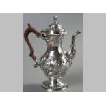 A GEORGE III SILVER COFFEE POT, LONDON 1764, F.C., hinged embossed cover with flame form finial, top