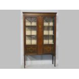 AN EDWARDIAN MAHOGANY DISPLAY CABINET, the moulded pediment above two astragal glazed doors flanking