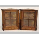 A NEAR PAIR OF 20TH CENTURY MIXED WOOD CORNER CABINETS, each with a rectangular glazed door above