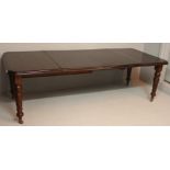 AN EDWARDIAN MAHOGANY EXTENDING DINING TABLE, the double moulded top with D-ends and two leaves,