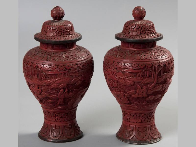 A PAIR OF CHINESE RED CINNABAR LACQUER BALUSTER VASES AND COVERS, heavily carved with scenes of