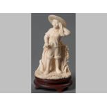 A FINE CHINESE IVORY FIGURE OF A BOY, holding a sickle and standing in a field, mid-20th Century,